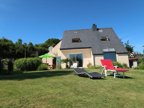 une maison avec deux chaises rouges dans la cour dans l'établissement Holiday Home Meeresblick by Interhome, à Kerouguel