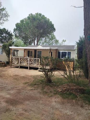 une maison avec une clôture devant dans l'établissement Camping le sainte marie, à Sainte-Marie-la-Mer
