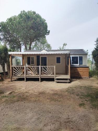 une petite maison avec un porche et une clôture dans l'établissement Camping le sainte marie, à Sainte-Marie-la-Mer