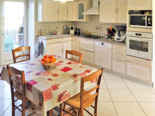 une cuisine avec une table avec un bol de fruits dessus dans l'établissement Holiday Home Les Grèzes by Interhome, à Montcabrier