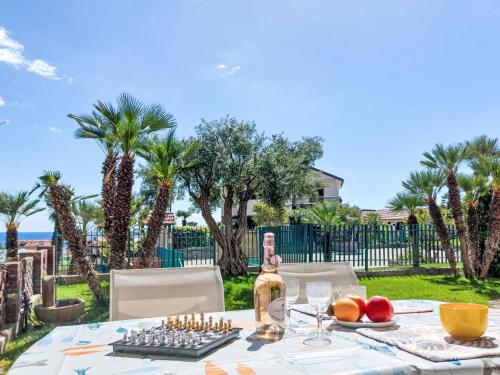 a table with a chess board and a bottle of wine at Apartment Le Margherite - SLR264 by Interhome in Costarainera