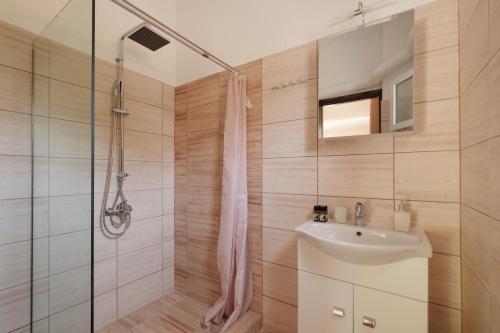 a bathroom with a shower and a sink at Agatha's spacious modern apt-1 in Perítheia