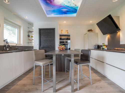 une cuisine avec une table, des chaises et un comptoir dans l'établissement Holiday Home Romane by Interhome, à Brignogan-Plage