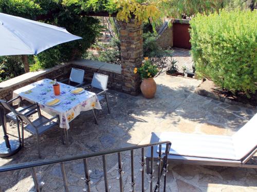un patio avec une table, des chaises et un parasol dans l'établissement Apartment Villa Montemare Dorette by Interhome, au Lavandou