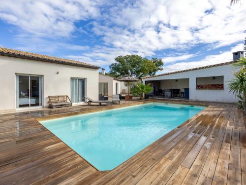 une piscine avec une terrasse en bois et une maison dans l'établissement Holiday Home Côté Sud by Interhome, à Corneilhan