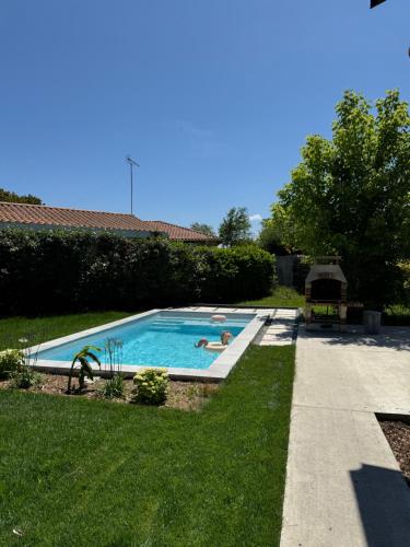 deux personnes allongées dans une piscine dans une cour dans l'établissement Le Lodge de l'océan - Maison familiale en bois neuve - Piscine chauffée, à Biscarrosse