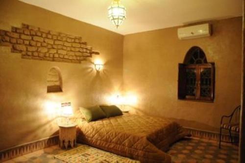 a bedroom with a bed in the corner of a room at La Rose Du Desert in Erfoud