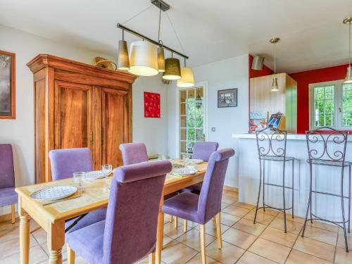 une salle à manger avec une table en bois et des chaises violettes dans l'établissement Holiday Home Le Chêne by Interhome, à Sabran