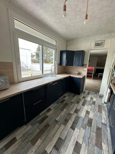 une cuisine avec un évier et une fenêtre dans l'établissement Maison - 150m plage- 4 personnes - Asnelles, à Asnelles
