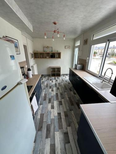 Il comprend une grande cuisine équipée d'un réfrigérateur et d'un évier. dans l'établissement Maison - 150m plage- 4 personnes - Asnelles, à Asnelles