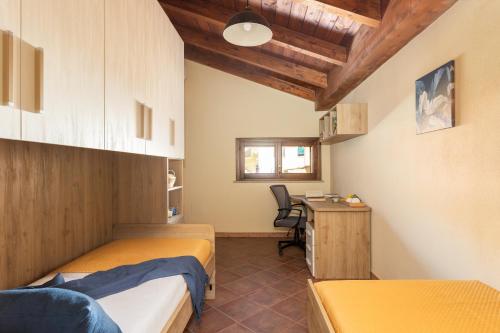 a bedroom with two beds and a desk and a table at Sant'Antioco - Spazioso appartamento al centro in SantʼAntìoco
