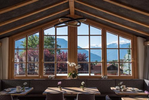 a restaurant with large windows with mountains in the background at Garni Marianne in Malles Venosta