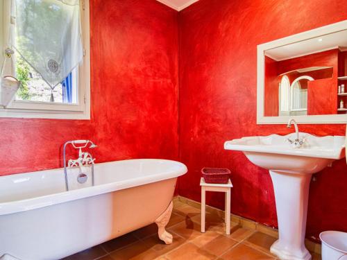 La salle de bains rouge est pourvue d'une baignoire et d'un lavabo. dans l'établissement Holiday Home Solena by Interhome, à Draguignan