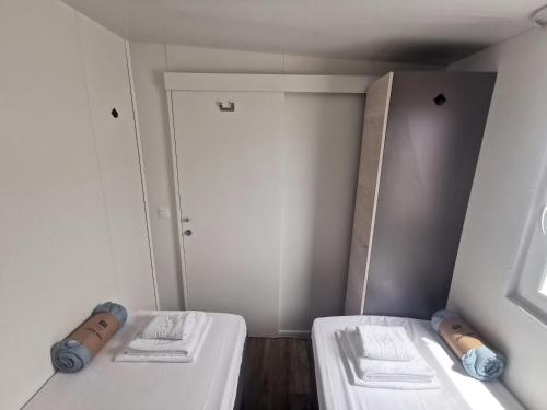 a small room with two beds and a closet at Mobile Home Happy Family Šimuni in Šimuni