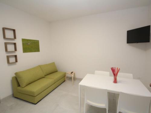 a living room with a green couch and a white table at Apartment Marcello-7 by Interhome in Rosolina Mare