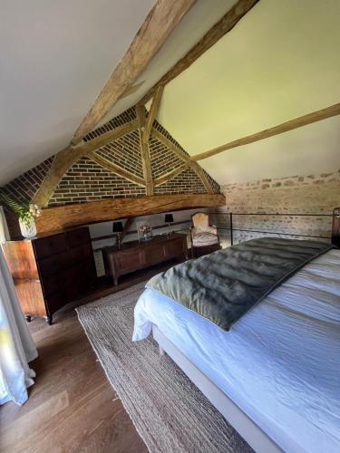 a bedroom with a large bed in a room at Le Clos des Songes in Blaru