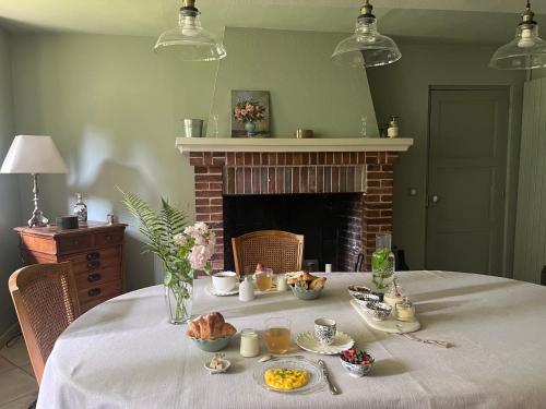 a table with food on it with a fireplace at Le Clos des Songes in Blaru