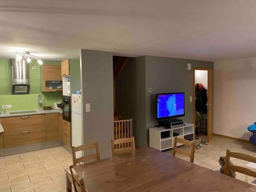 a living room with a dining table and a kitchen at Logement 7pers-80m2 avec terrasse & jardin in Gries