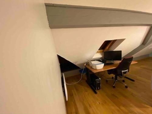 a room with a desk and a computer in an attic at Logement 7pers-80m2 avec terrasse & jardin in Gries