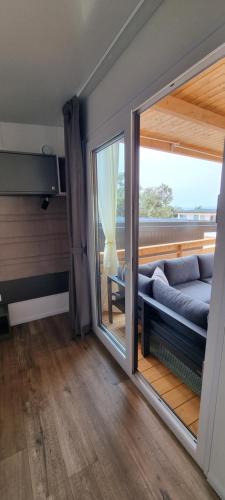 a living room with a couch and a large window at Mobile Home Happy Family Šimuni in Šimuni