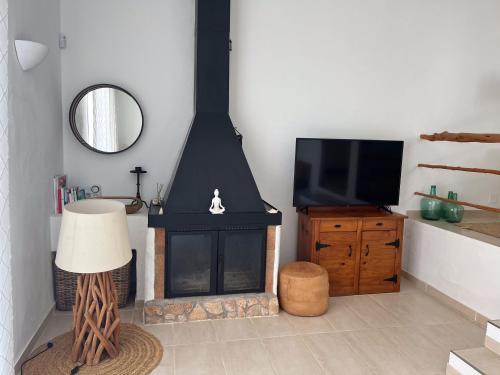 a living room with a fireplace and a television at Boutique Hotel CASA CARACOL - Apartments in Strandnähe, Salzwasserpool, Fotovoltaik, Adults Only in San Jose