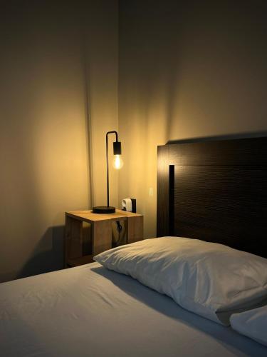 a bedroom with a bed and a lamp on a night stand at Joannas Airport Luxury Rooms in Artemida