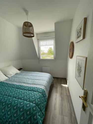 une petite chambre avec un lit et une fenêtre dans l'établissement Les Belles Rives T2 avec balcon ensoleillé, à Cabourg