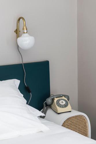 a phone sitting on a bed next to a lamp at Domaine La Gentilhommière in Satillieu