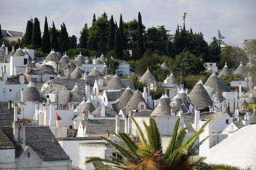 a village with white houses and palm trees at Villa Clara in Alberobello