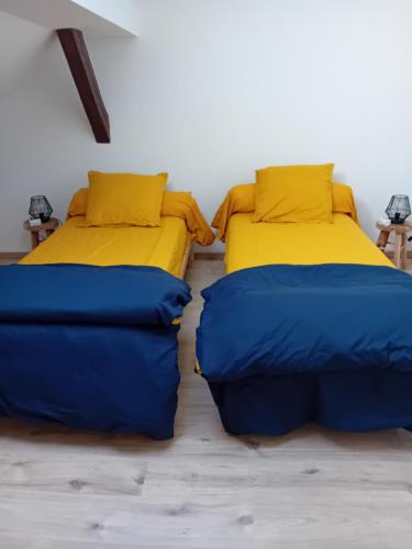 deux lits côte à côte dans une pièce dans l'établissement La Bienvenue, à Saint-Michel-sur-Meurthe