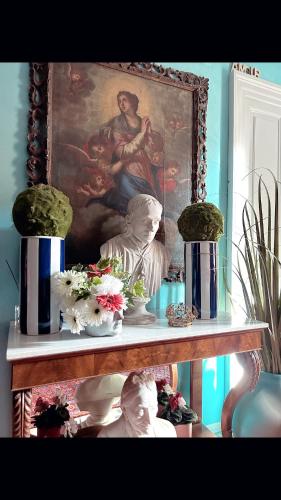 a shelf with a painting and vases with flowers on it at Art action room 