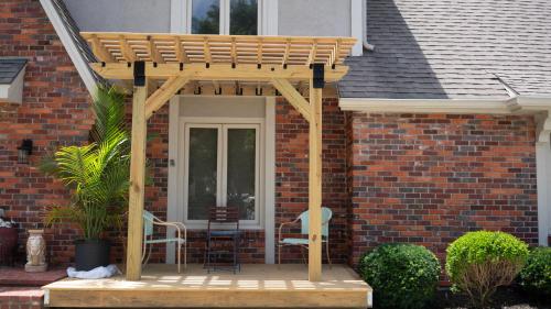 a patio with two chairs and a wooden pergola at Casa Grande Luxur in Overland Park