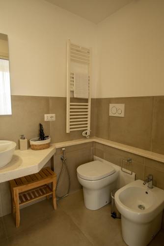 a bathroom with a white toilet and a sink at Locanda dei Buoni e Cattivi in Cagliari