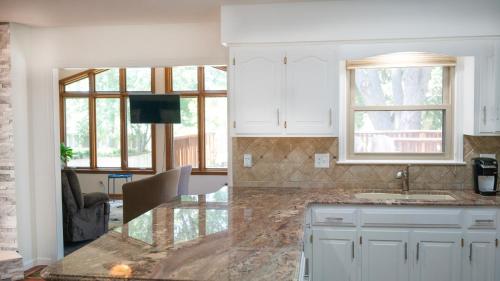 a kitchen with white cabinets and a marble counter top at Casa Grande Luxur in Overland Park