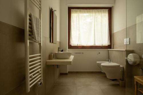 a bathroom with a sink and a toilet and a window at Locanda dei Buoni e Cattivi in Cagliari
