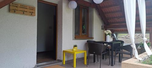 a patio with chairs and a table with a yellow stool at Apartmán nad vínnym sklepom in Pouzdřany