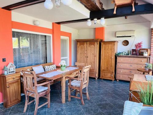 a dining room with a wooden table and chairs at Vadvirág Apartmanház in Gyomaendrőd