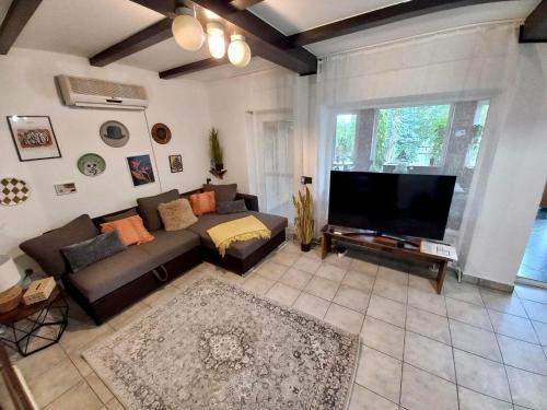 a living room with a couch and a flat screen tv at Vadvirág Apartmanház in Gyomaendrőd