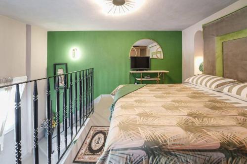a bedroom with a bed and a green wall at La Finestra sul Castello in Ischia