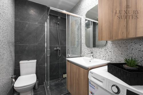a bathroom with a toilet and a shower and a sink at Adelle Apartments, The Luxury Suites in Thessaloniki