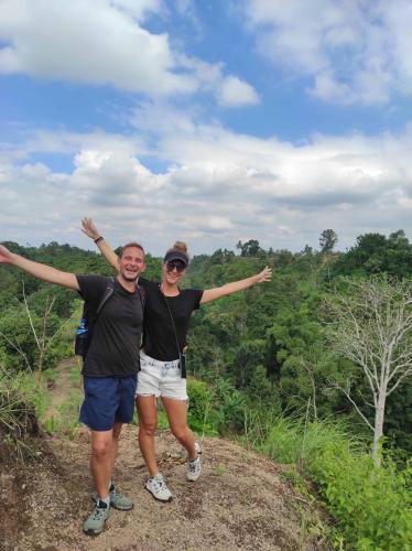 two people standing on top of a hill with their arms out at Tastura Homestay in Praya