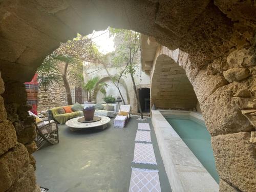 - une piscine au milieu d'un bâtiment en pierre dans l'établissement Le Petit Palais Hors Du Temps, à Collias