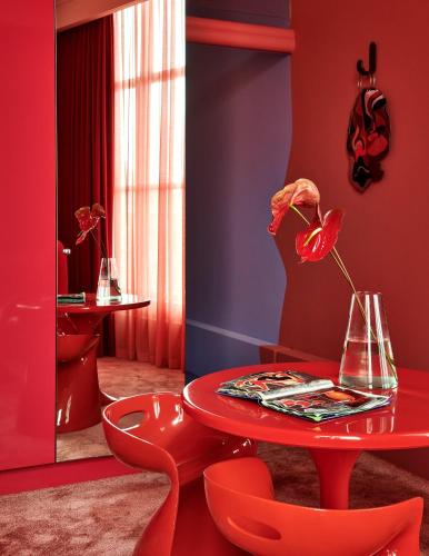 a red room with a red table and red chairs at De L’Europe Amsterdam – The Leading Hotels of the World in Amsterdam
