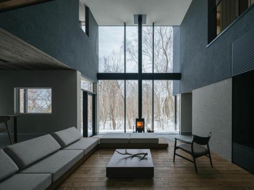 a living room with a couch and a chair at 山郷 Villas in Nature in Otaru
