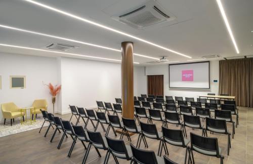 a lecture hall with chairs and a screen at Leonardo Hotel Lago di Garda - Wellness and Spa in Lazise