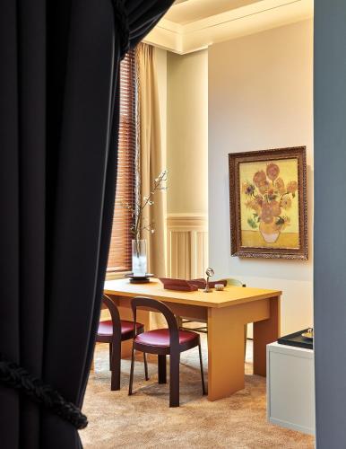 a room with a desk and two chairs and a table at De L’Europe Amsterdam – The Leading Hotels of the World in Amsterdam