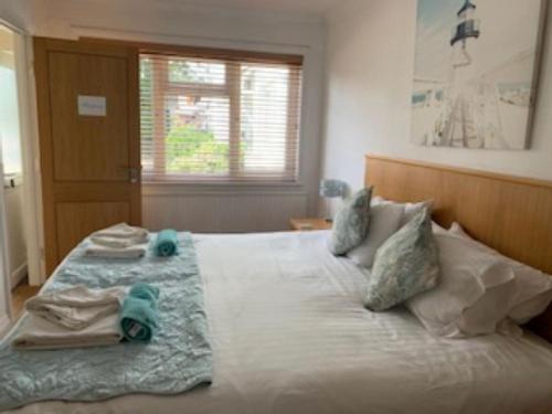 um quarto com uma grande cama branca com animais de peluche em Goodrington Lodge Holiday Apartments em Paignton