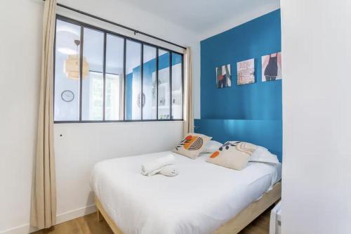 une chambre avec un lit et une grande fenêtre dans l'établissement Jolie appartement proche de la joliette 14LAN, à Marseille