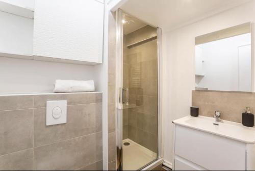 une salle de bain avec une douche, un lavabo et un miroir dans l'établissement Jolie appartement proche de la joliette 14LAN, à Marseille