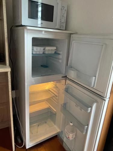 an open refrigerator with a microwave on top of it at コンドミニアム　アガサンクス in Kuki